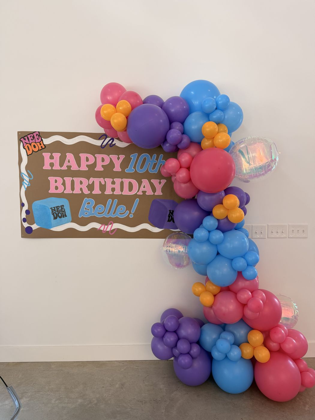 Happy 10th Birthday Belle banner with a colorful balloon garland