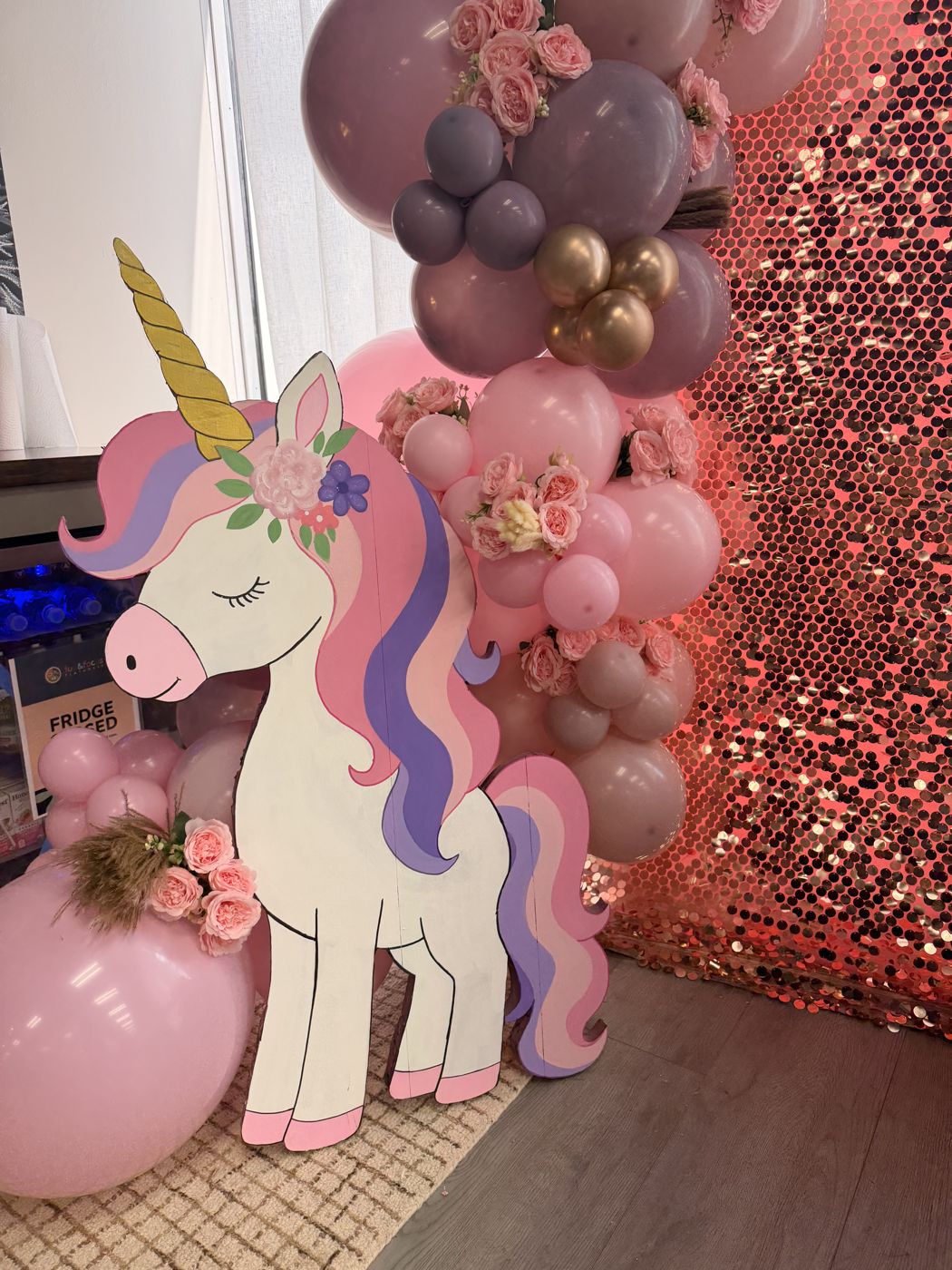 Unicorn cutout with a pink and mauve balloon garland